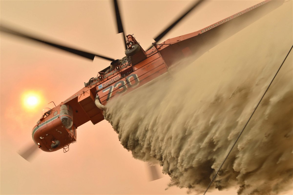 A helicopter drops fire retardant to protect a property in Balmoral, 150 kilometres southwest of Sydney on December 19. A state of emergency was declared in Australia's most populated region as a record heat wave fanned unprecedented bushfires. 