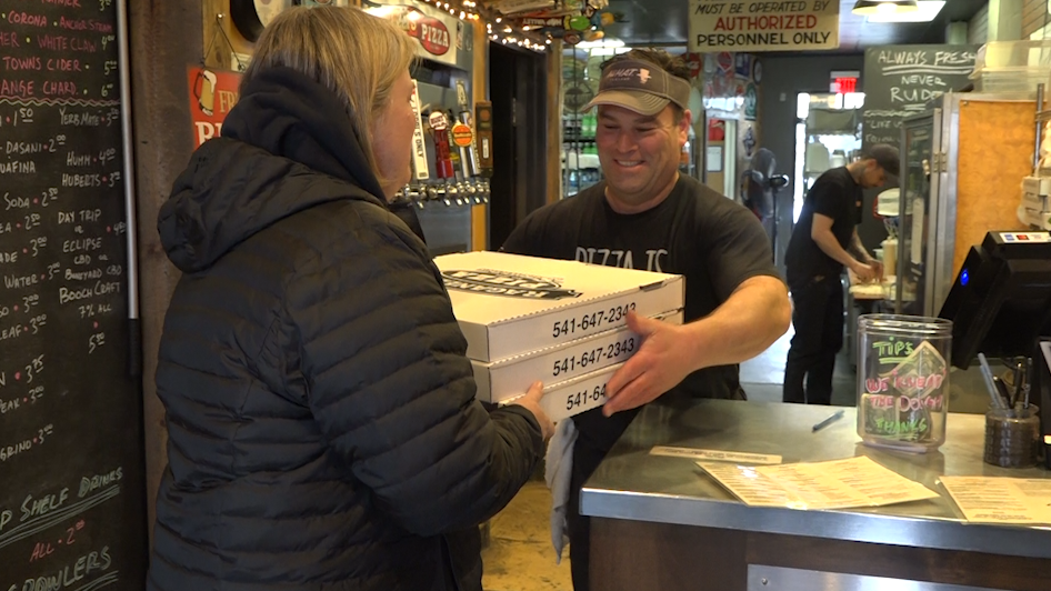 Raganelli's Chief Pizza Czar Patrick MacCrone hand Silver Rail Elementary's Principal Tammy Doty a few of the several pizzas that will be donated throughout the Bend community.
