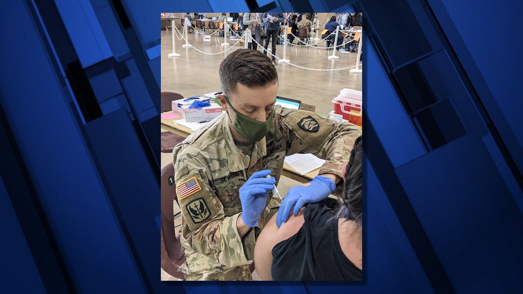Oregon National Guard Spc. Toby SeWell assigned to the Oregon Army National Guard Medical Command, administers the COVID-19 vaccination to a Salem resident at the Oregon State Fairgrounds in Salem in January 2021