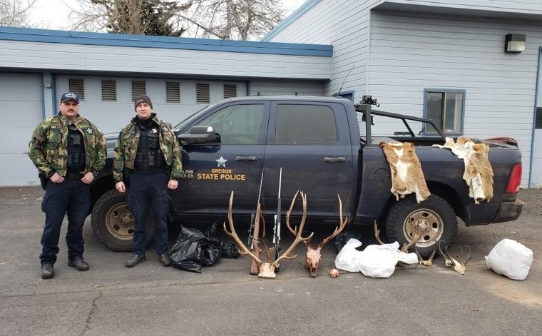 OSP Fish and Wildlife Troopers Tom Juzeler, left, of Pendleton, and Kameron Gordon, right, of Klamath Falls, with evidence seized in recent case that highlights risks of chronic wasting disease, and lending/borrowing tags