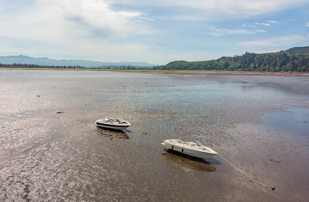 Rescuers assisted some of 13 people stranded after 2 boats got stuck in the mud Saturday on Tillamook Bay