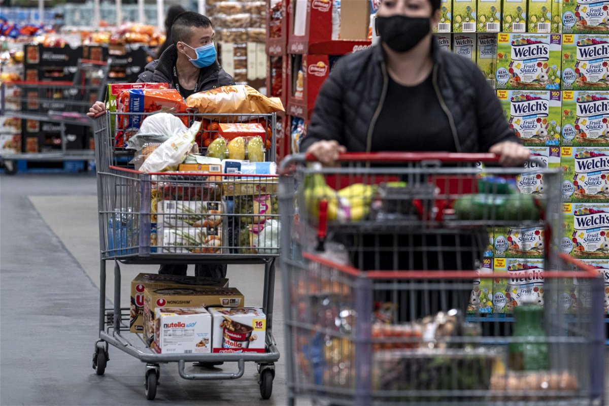 Shoppers wearing protective masks push shopping carts inside a Costco store in San Francisco on March 3