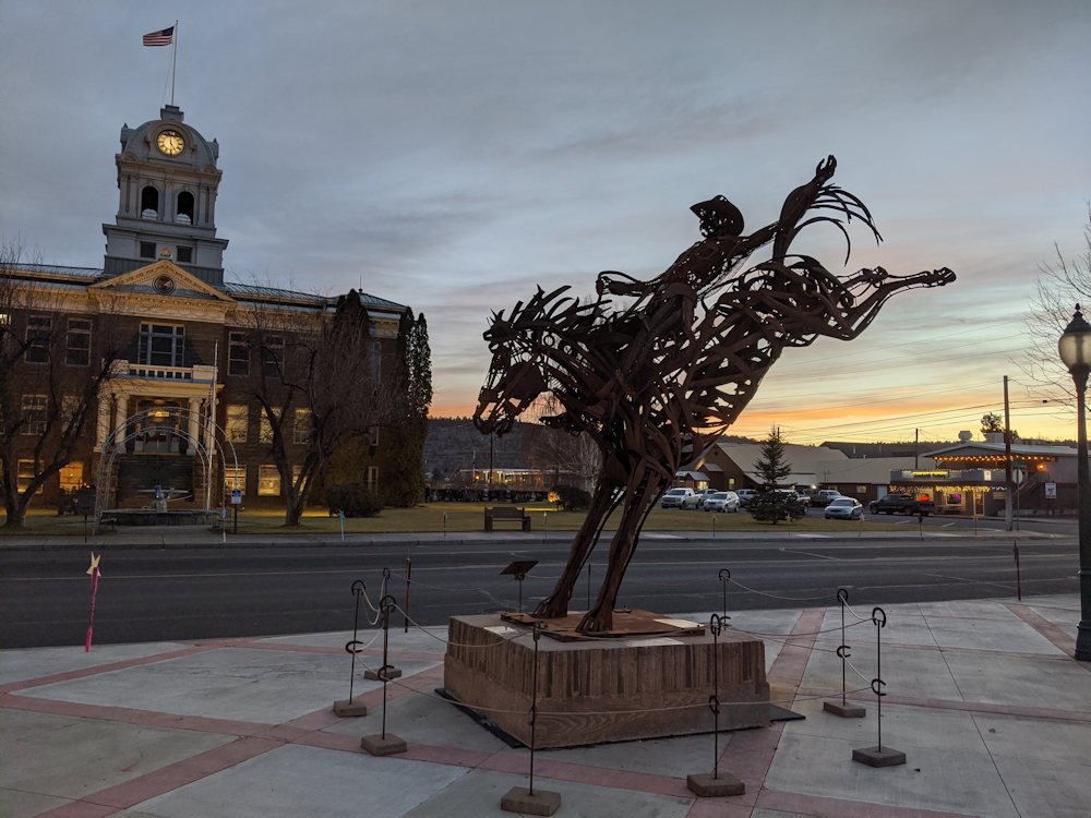 Greg Congleton sculpture, 'War Horse,' at dusk, with Crook County Courthouse in the background