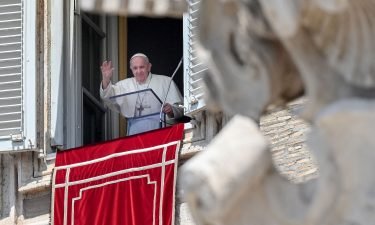 Pope Francis waves from a window overlooking St. Peter's Square in the Vatican during the weekly Angelus prayer followed by the recitation of the Regina Coeli on May 9.