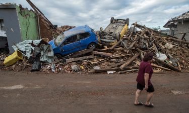 A woman walks past the debris of damaged buildings on June 25 in the village of Mikulcice in the Czech Republic after it was hit by a tornado.