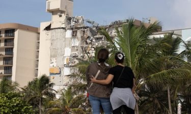 Maria Fernanda Martinez and Mariana Cordeiro look on as search and rescue operations continue at the site of the partially collapsed condo building on Friday in Surfside.