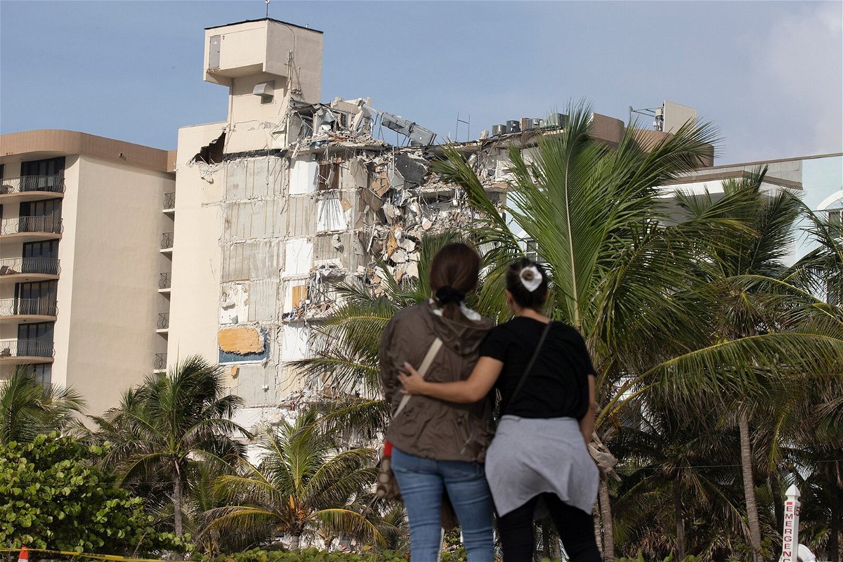 <i>Joe Raedle/Getty Images</i><br/>Maria Fernanda Martinez and Mariana Cordeiro look on as search and rescue operations continue at the site of the partially collapsed condo building on Friday in Surfside.