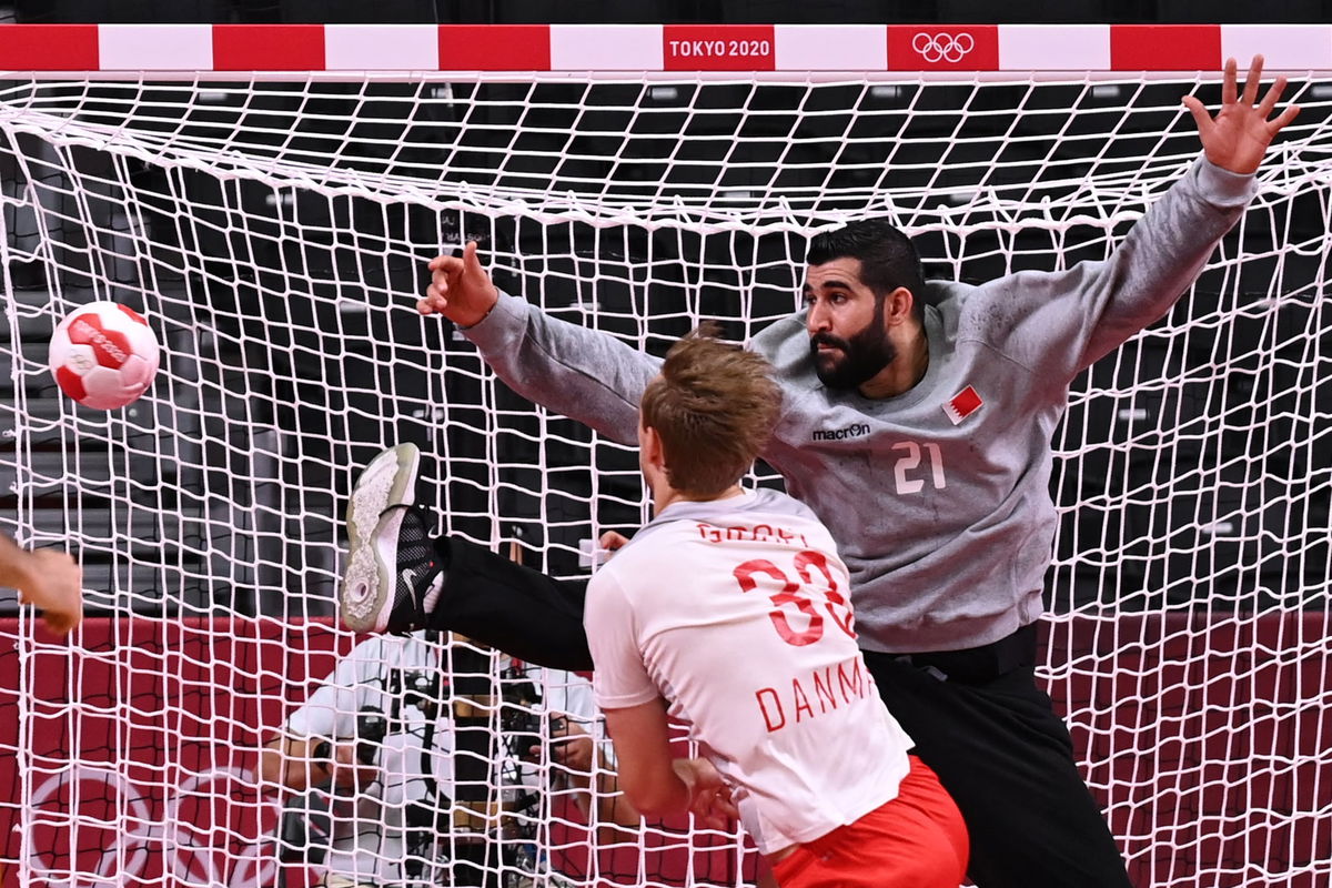 Bahrain's goalkeeper Mohamed A.Husain (R) fails to stop a shot during the men's preliminary round Group B handball match between Denmark and Bahrain of the Tokyo 2020 Olympic Games.