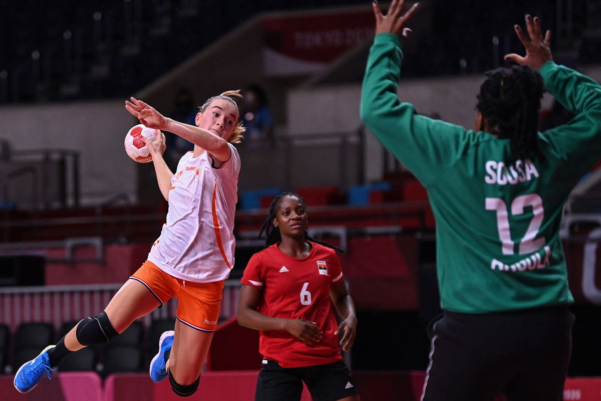 Netherlands' left wing Bo van Wetering (L) jumps to shoot during the women's preliminary round group A handball match between The Netherlands and Angola