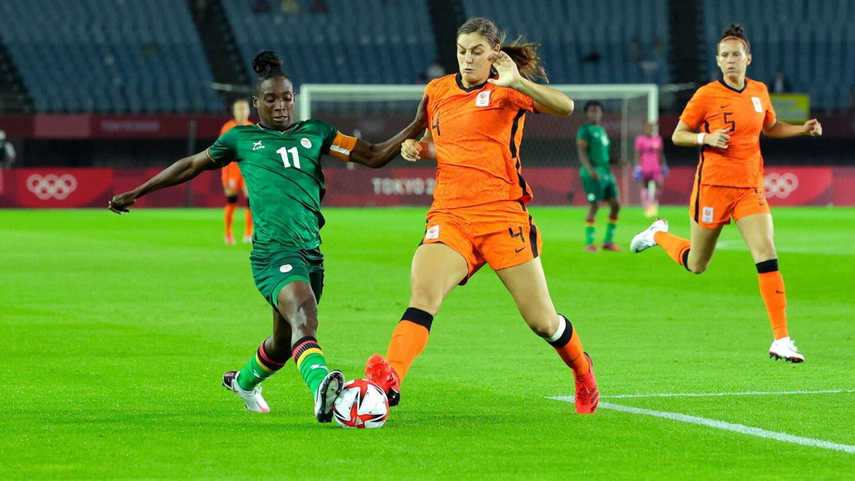 A player from Zambia and a player from Netherlands fight for the ball.