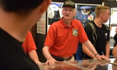 Gwinnett Veterans Memorial Museum volunteer Frank Dermer talks to Jackson County High School and East Jackson High School JROTC students during their recent visit to the museum.