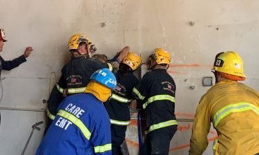 Crews rescued a woman who became trapped between two buildings in Santa Ana Tuesday afternoon.