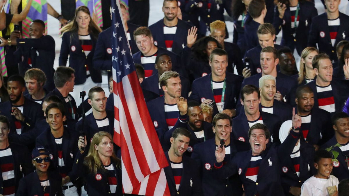 Michael Phelps carries the U.S. flag in front of a group of American athletes.