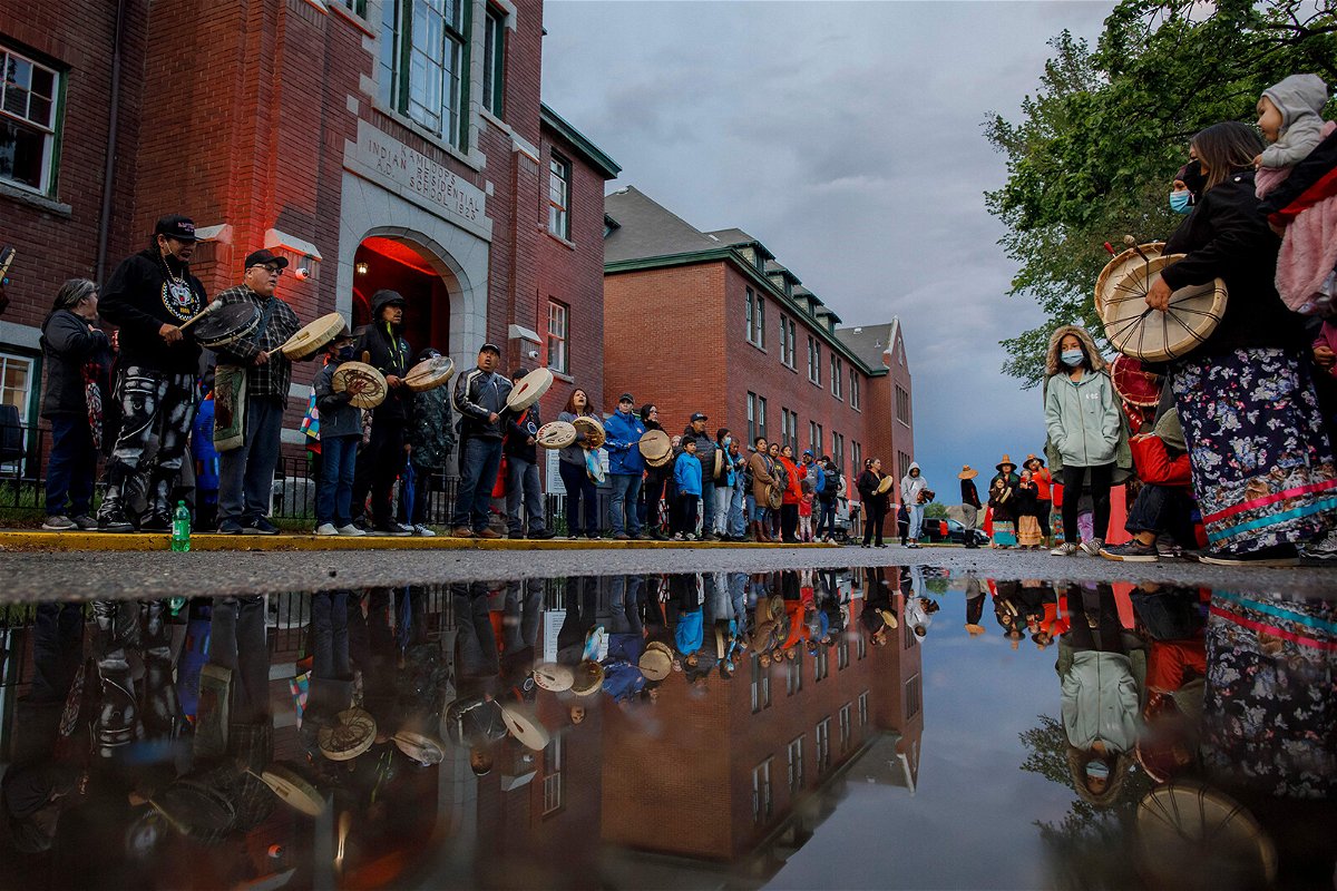 <i>Cole Burston/AFP/Getty Images</i><br/>Drummers line the front of the former Kamloops Indian Residential School to welcome a group of runners from the Syilx Okanagan Nation on June 5.