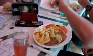 A man adds salt to his fish and chips in a British restaurant in Benidorm