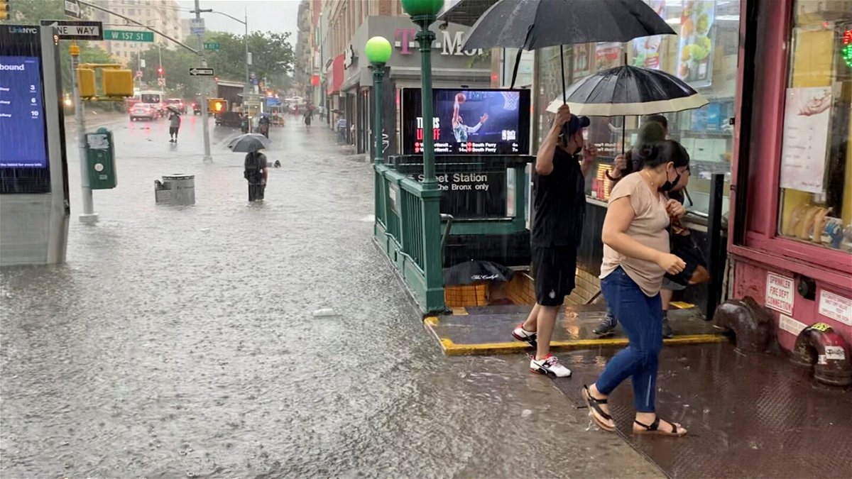 <i>Stephen Smith/Reuters</i><br/>A person wades through floodwater as people exit the 157th St. metro station in New York City on July 8.