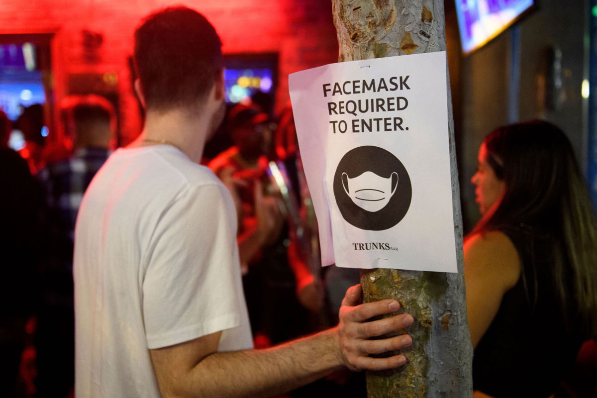 <i>Patrick T. Fallon/AFP/Getty Images</i><br/>Face mask signage is displayed outside the Trunks bar after midnight early Sunday morning in West Hollywood