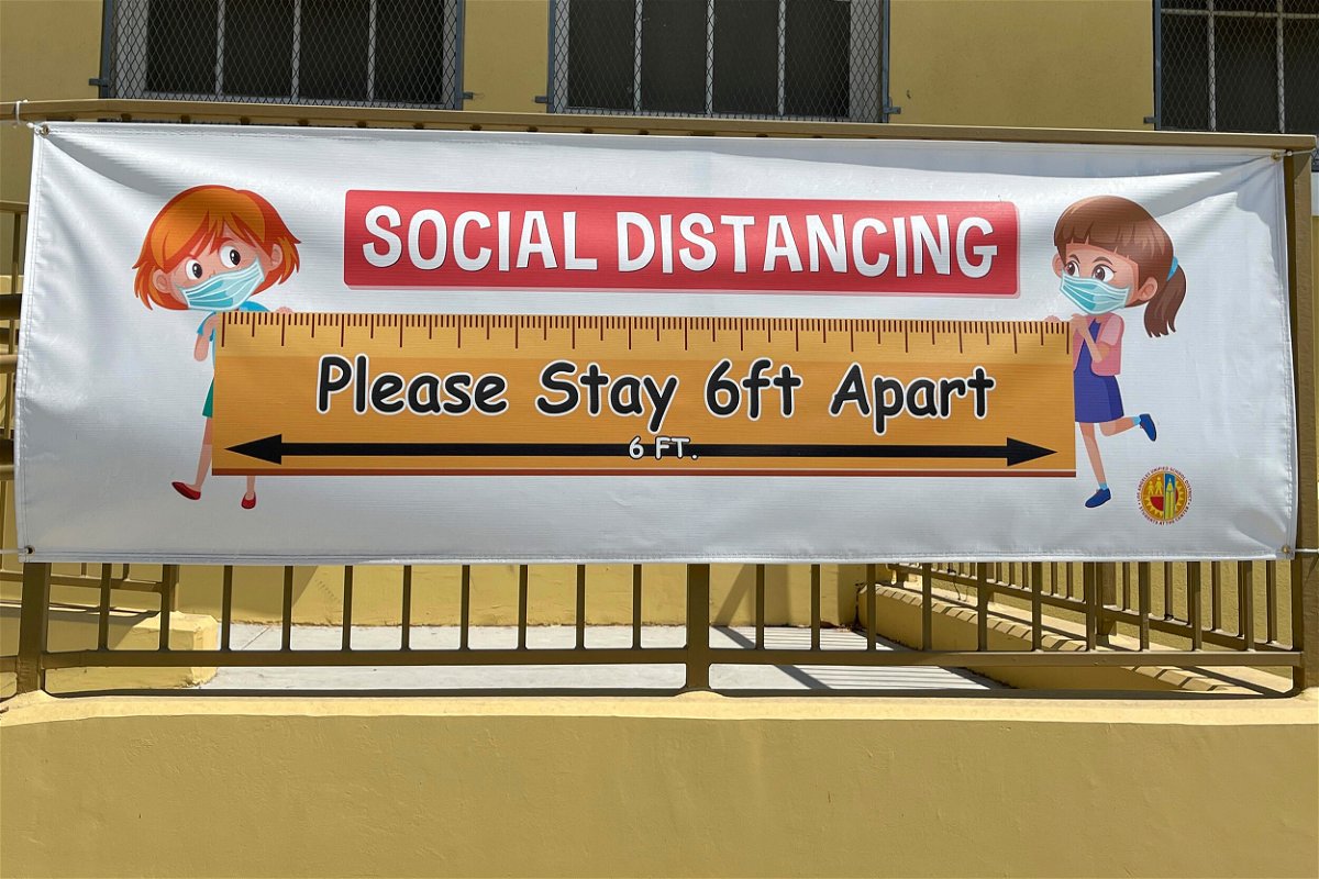 <i>Kirby Lee/AP/FILE</i><br/>A social distancing sign hangs at Morris K. Hamasaki Elementary School in Los Angeles on July 1. New Covid-19 cases among children are back on the rise after months of declines