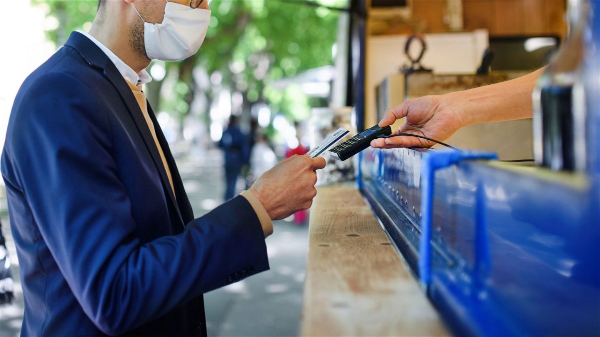 <i>Halfpoint Images/Moment RF/Getty Images</i><br/>A man pays at a coffee stall. The US economy is showing signs of recovery. That could also mean spending more money on activities that people may not have done in a while -- like going to the movies