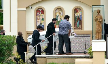 Pallbearers carry the casket of two sisters killed in the Sunrise