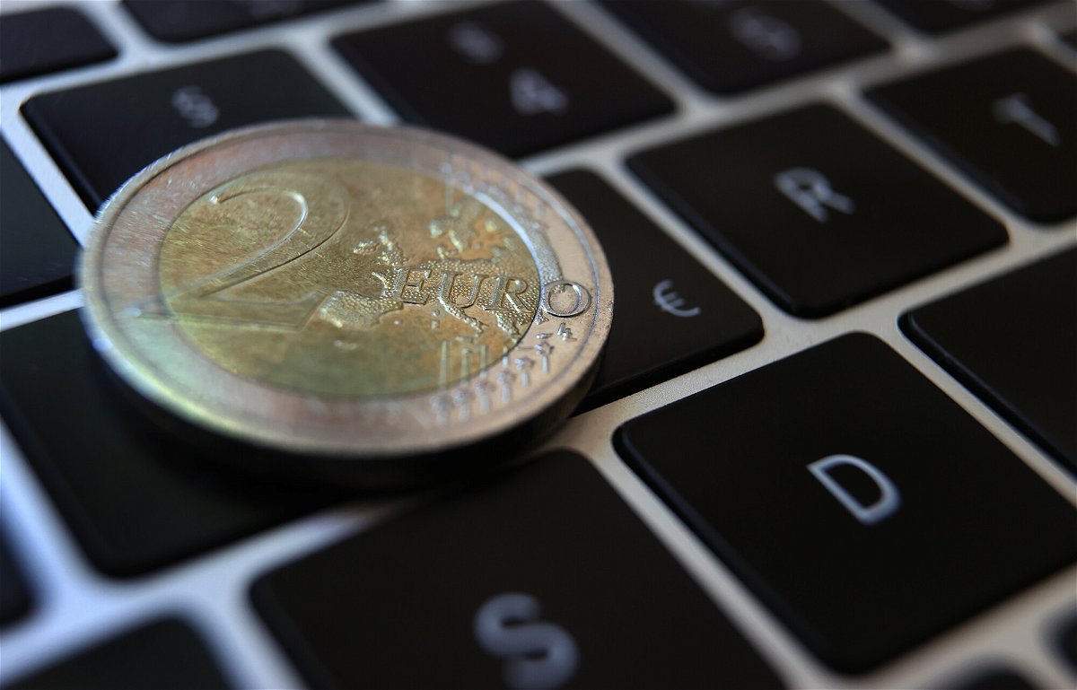 <i>Karl-Josef Hildenbrand/picture alliance/Getty Images</i><br/>A two-euro coin lies on the keyboard of a laptop next to a euro sign. The European Central Bank is moving ahead with efforts to create a digital version of the euro as the use of cash declines and China ramps up tests of its own e-yuan.