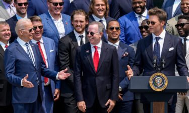 President Joe Biden laughs as quarterback Tom Brady jokes while speaking as the 2021 NFL Super Bowl champion Tampa Bay Buccaneers are welcomed to the South Lawn of the White House on July 20 in Washington