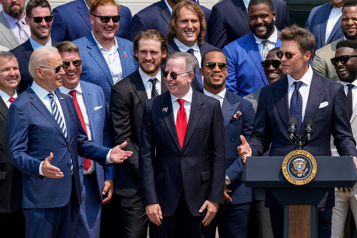 <i>Drew Angerer/Getty Images</i><br/>President Joe Biden laughs as quarterback Tom Brady jokes while speaking as the 2021 NFL Super Bowl champion Tampa Bay Buccaneers are welcomed to the South Lawn of the White House on July 20 in Washington
