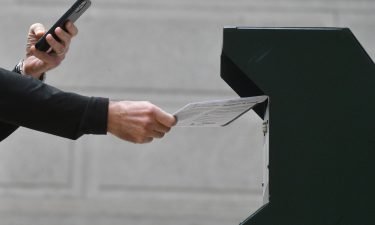 A man deposits his ballot at the satellite polling station on October 27