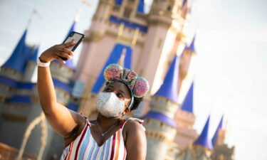 A guest stops to take a selfie at Magic Kingdom Park at Walt Disney World Resort on July 11