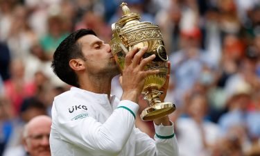 Novak Djokovic kisses the winner's trophy after beating Italy's Matteo Berrettini at Wimbledon.