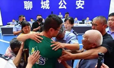 Guo Xinzhen (center) embraces his family at a reunion in Liaocheng