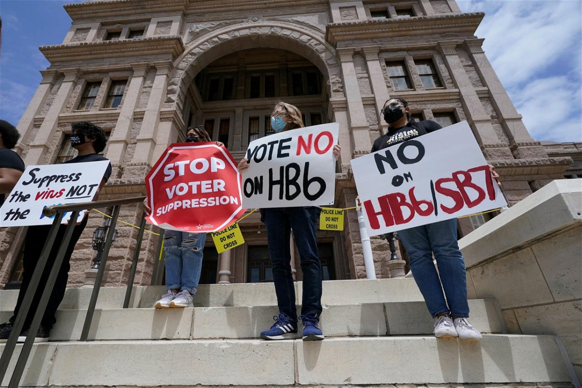 <i>Eric Gay/AP</i><br/>People opposed to Texas voter bills HB6 and SB7 hold signs during a news conference hosted by Texas Rising Action on the steps of the State Capitol in Austin