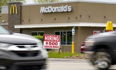 Hourly earnings are rising. A hiring sign offers a $500 bonus outside a McDonalds restaurant