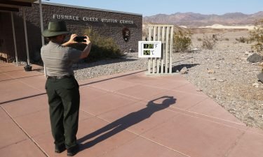 A park ranger takes a picture of an unofficial thermometer at Furnace Creek Visitor Center in California's Death Valley National Park on August 17
