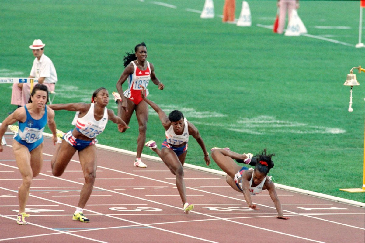 <i>KAZUHIRO NOGI/AFP/AFP via Getty Images</i><br/>Devers (right) dives across the finish line of the 100m hurdles final at the 1992 Olympics having hit the last hurdle.