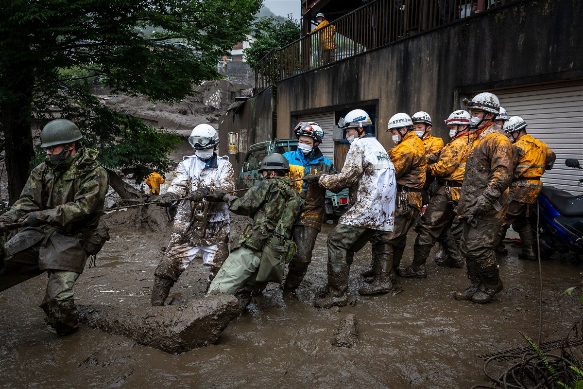 <i>Yuichi Yamazaki/Getty Images</i><br/>Rescue workers pull a rope to remove debris from a house damaged by a landslide on July 04 in Atami