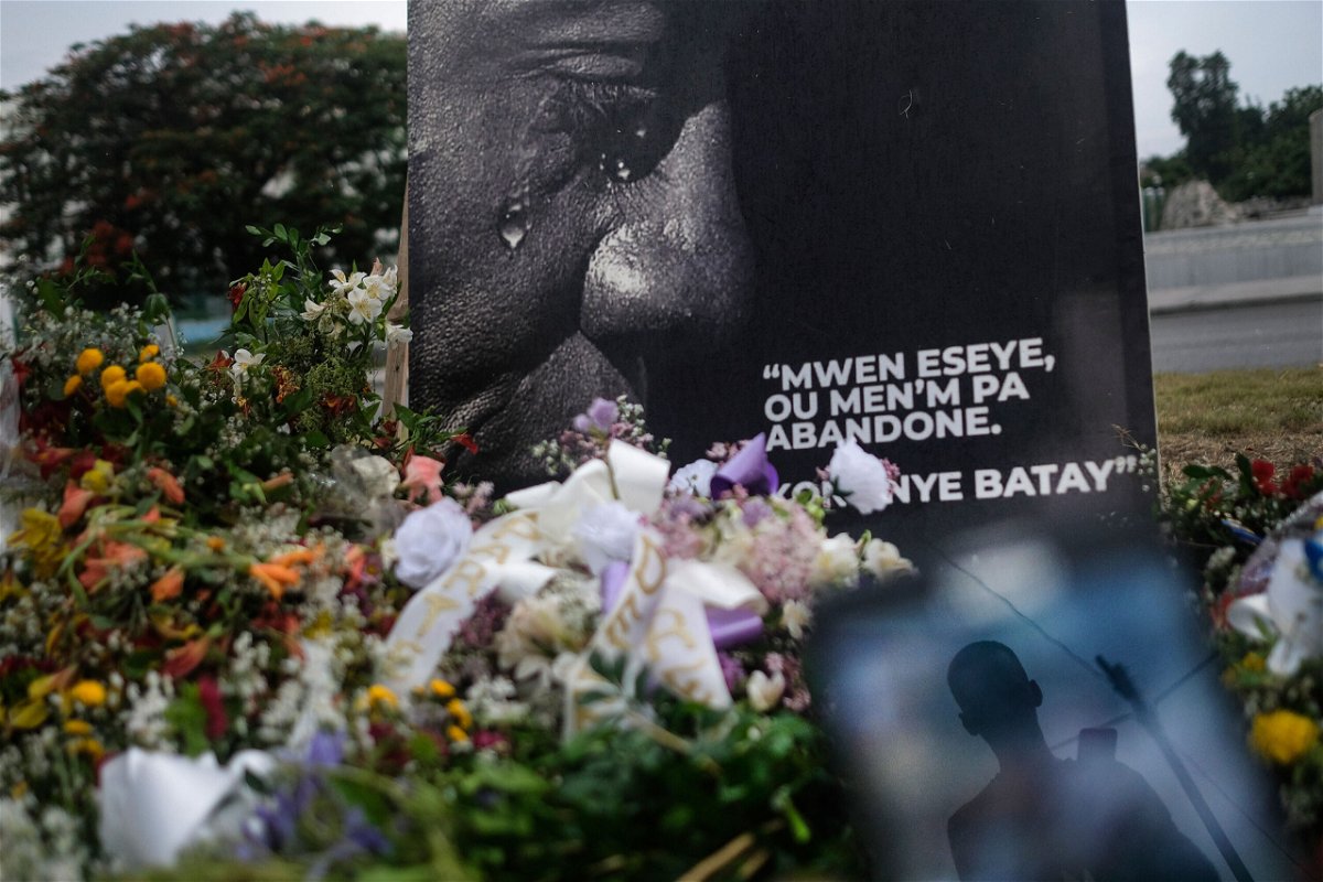 <i>Matias Delacroix/AP</i><br/>A man is reflected on a cellphone at a memorial outside the Presidential Palace in memory of slain President Jovenel Moise