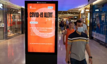 People pass a new Covid-19 Alert Public Health England