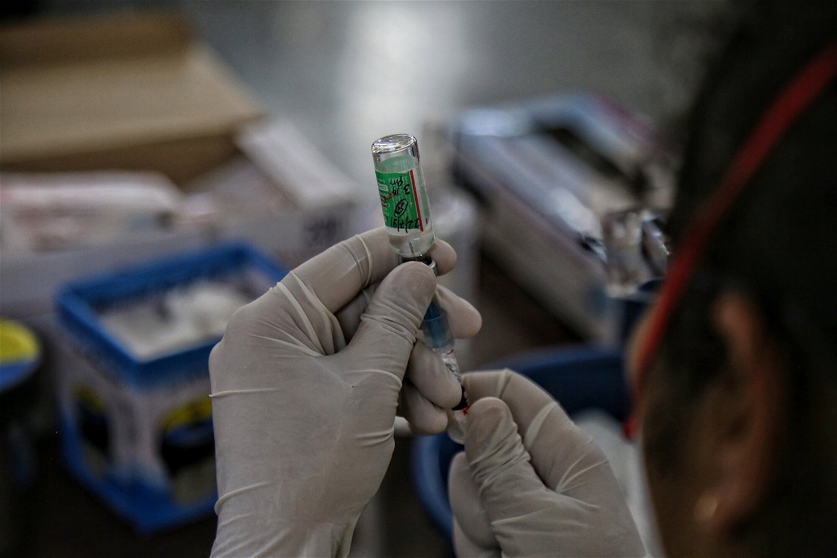 <i>Sanchit Khanna/Hindustan Times/Getty Images</i><br/>A health worker prepares a dose from a vial of Covishield vaccine at a Covid-19 vaccination centre