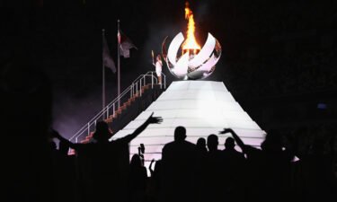 Naomi Osaka of Team Japan lights the Olympic cauldron with the Olympic torch during the opening ceremony of the Tokyo 2020 Olympic Games on Friday