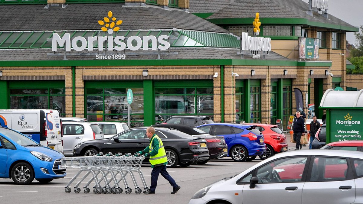 <i>Anthony Devlin/Bloomberg/Getty Images</i><br/>A worker pushes shopping trolleys through a Morrisons supermarket parking lot near the company's head offices in Bradford