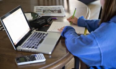 A high school student works on an assignment on a laptop computer at home during a remote learning day in Tiskilwa