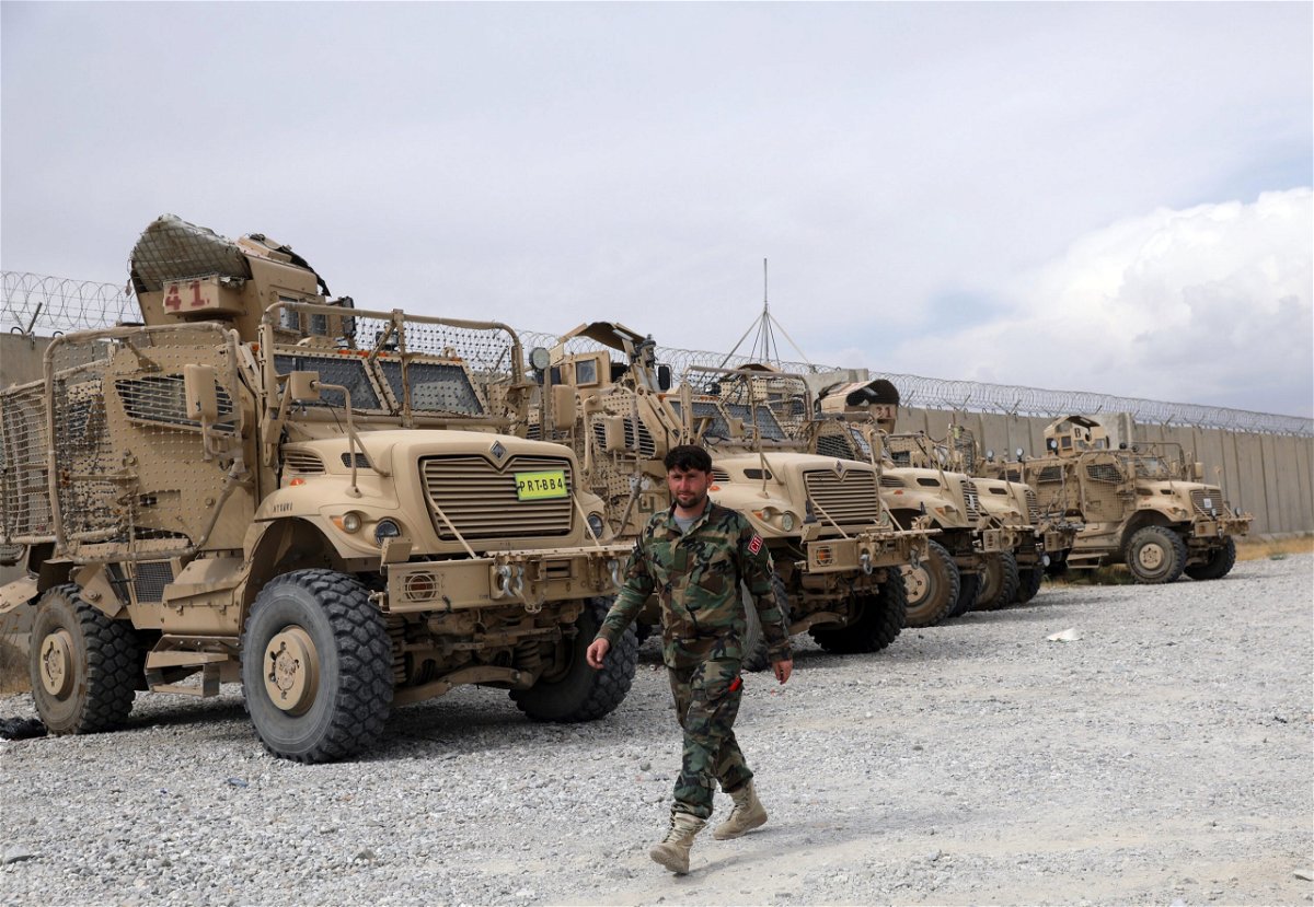 <i>Rahmat Gul/AP</i><br/>An Afghan army soldier walks past Mine Resistant Ambush Protected vehicles