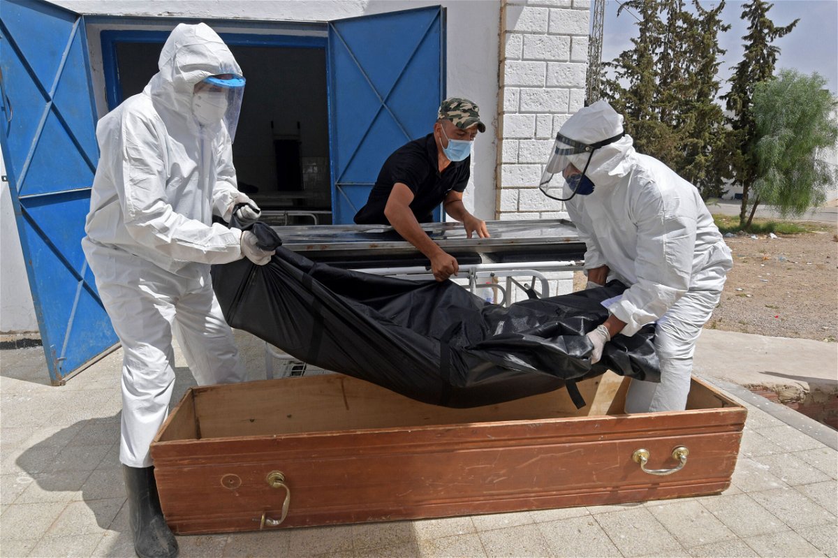 <i>Fethi Belaid/AFP/Getty Images</i><br/>The body of a Covid-19 victim is placed into a casket at the Ibn al-Jazzar hospital in the Tunisian city of Kairouan on July 4.