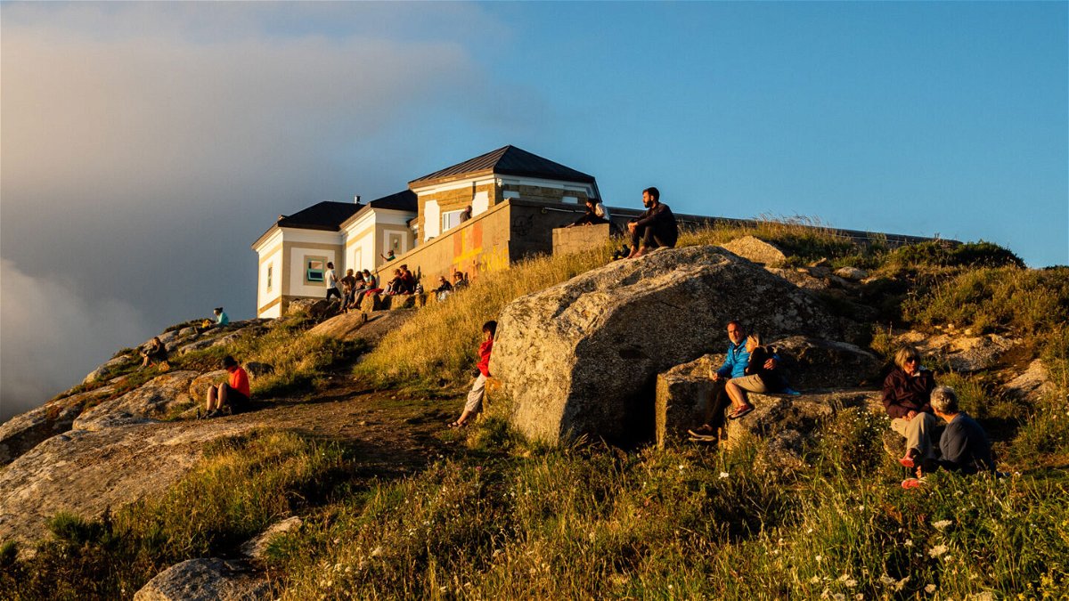 <i>Ana Fernandez/SOPA Images/LightRocket/Getty Images</i><br/>Pilgrims and tourists are seen waiting for the sunset at the Cape Finisterre. Cape Finisterre is the destination of those pilgrims who