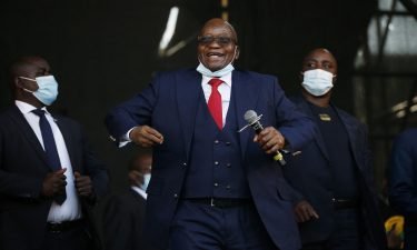 Former South African President Jacob Zuma dances on stage before addressing his supporters following the postponement of his corruption trial outside the Pietermaritzburg High Court in Pietermaritzburg