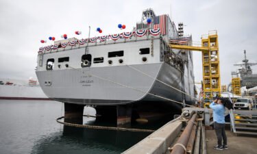 A television cameraman videotapes the USNS John Lewis before a christening ceremony on July 17 in San Diego.