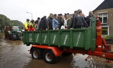People ride on a trailer as the Dutch fire brigade evacuate people from their homes in South Limburg.