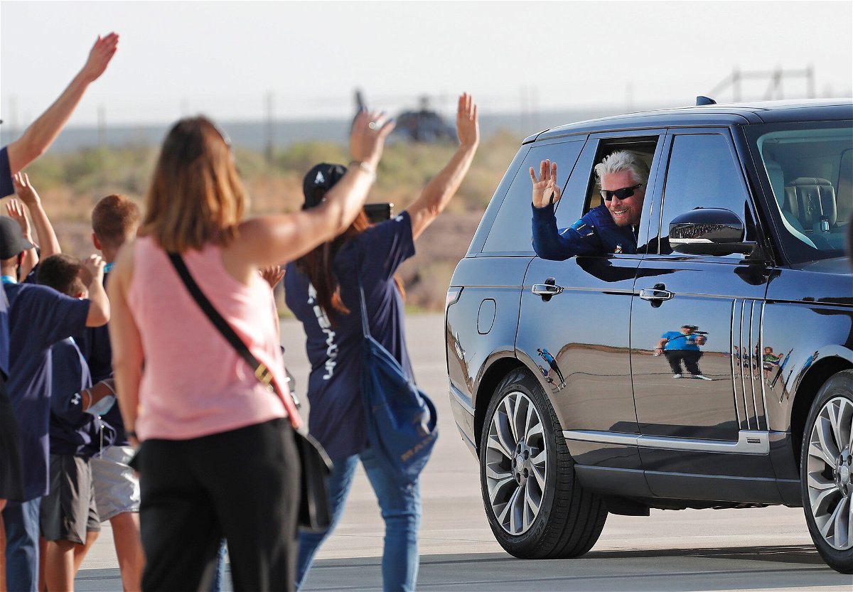 <i>Andres Leighton/AP</i><br/>Virgin Galactic founder Richard Branson waves to school children while heading to board the rocket plane that will fly him to space from Spaceport America near Truth or Consequences