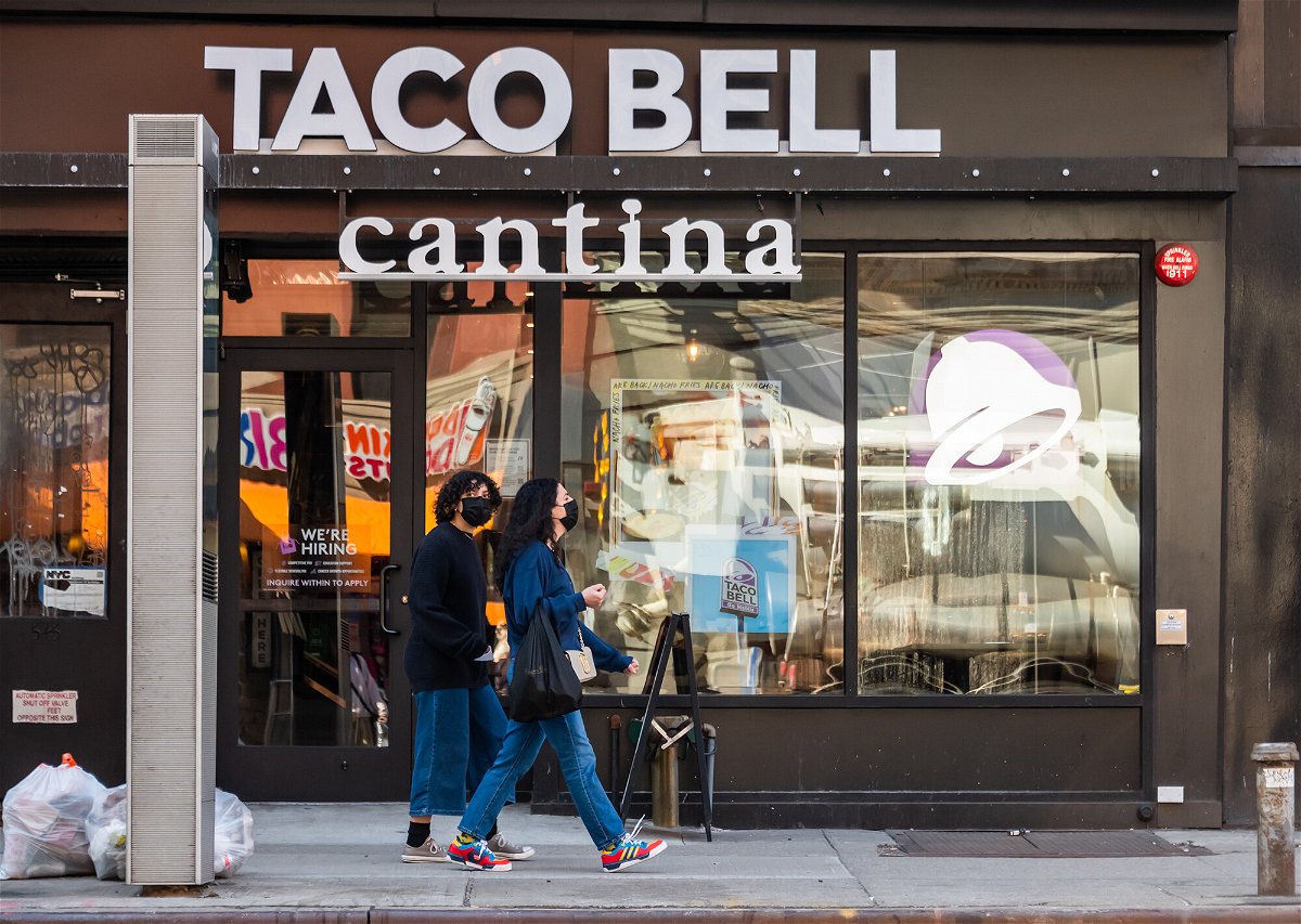 <i>Noam Galai/Getty Images</i><br/>Two people wearing masks walk by a Taco Bell Cantina on March 21 in New York City. The chain apologized on its website July 20